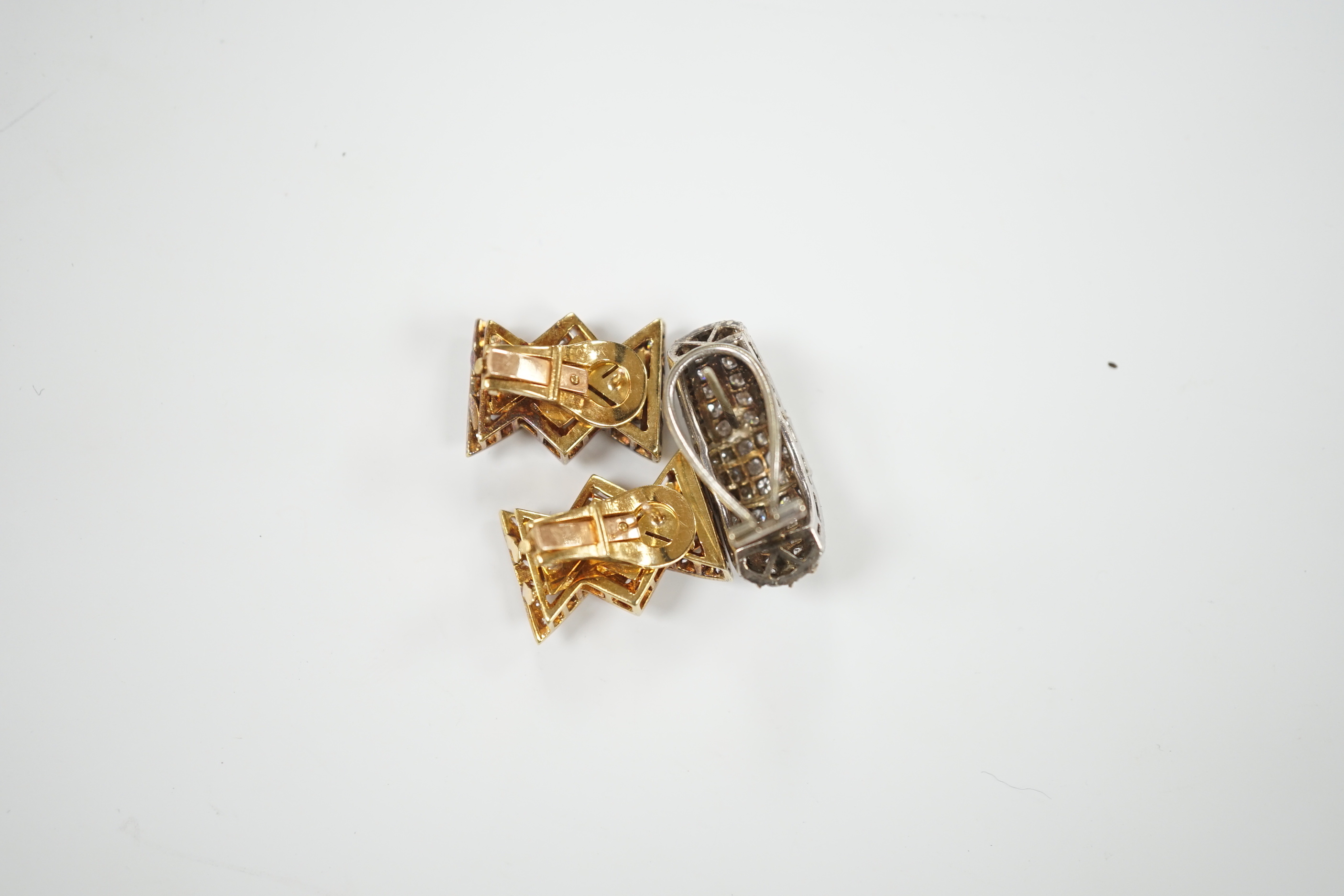 A pair of yellow metal and diamond chip cluster set earrings, of stylised bow form, 19mm and one other demi-lune shaped white metal and diamond cluster set earring, gross weight 17.7 grams.